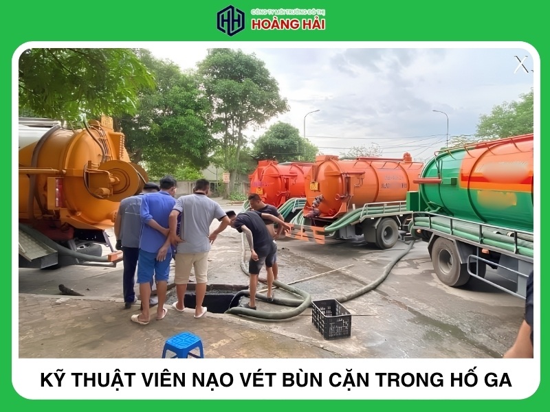 kỹ thuật viên đang nạo vét bùn cặn trong hố ga thoát nước