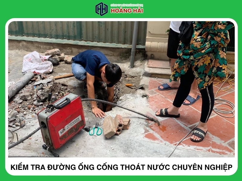 kỹ thuật viên kiểm tra đường ống cống thoát nước bằng thiết bị chuyên dụng